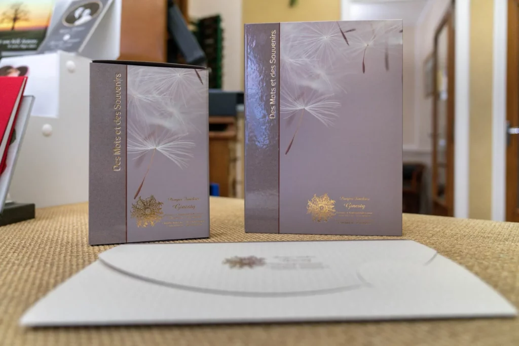 Livres de condoléances et enveloppe posés sur un comptoir d'accueil.